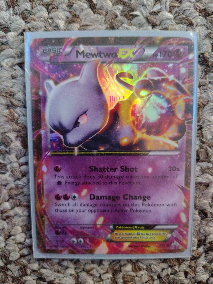 KNOWN FAKE — educational sample: counterfeit Mewtwo EX printed with the number XY106, from the shop's October 2026 trade lot, photographed by the shop